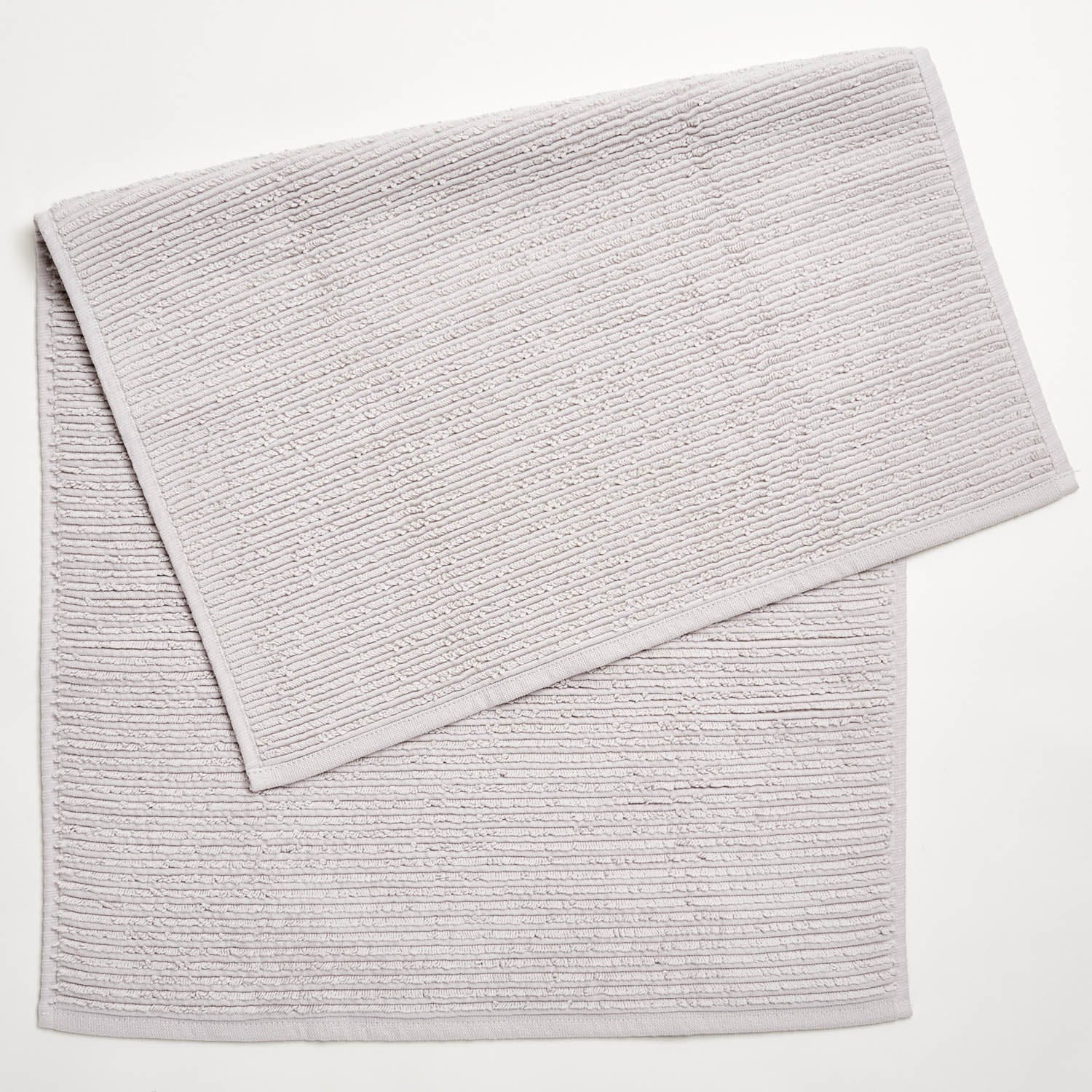 Folded textured towel with ribbing pattern on white background.