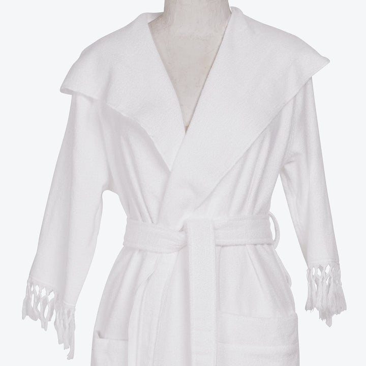 A plush, white bathrobe with shawl collar and decorative tassels.