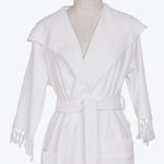 A plush, white bathrobe with shawl collar and decorative tassels.