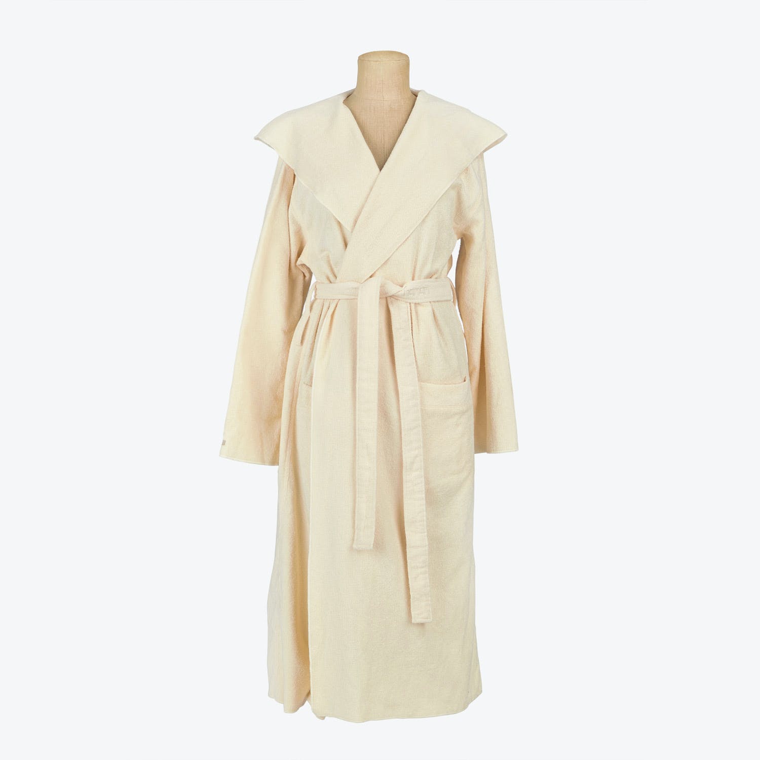 Pale-colored plush bathrobe with shawl collar and wraparound style.