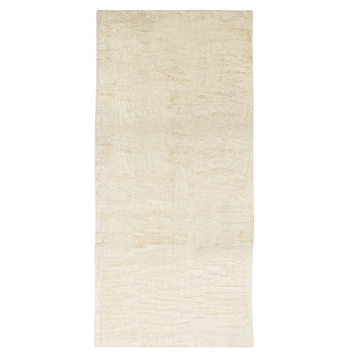 Simple, plush cream rug on white background, minimalistic design.