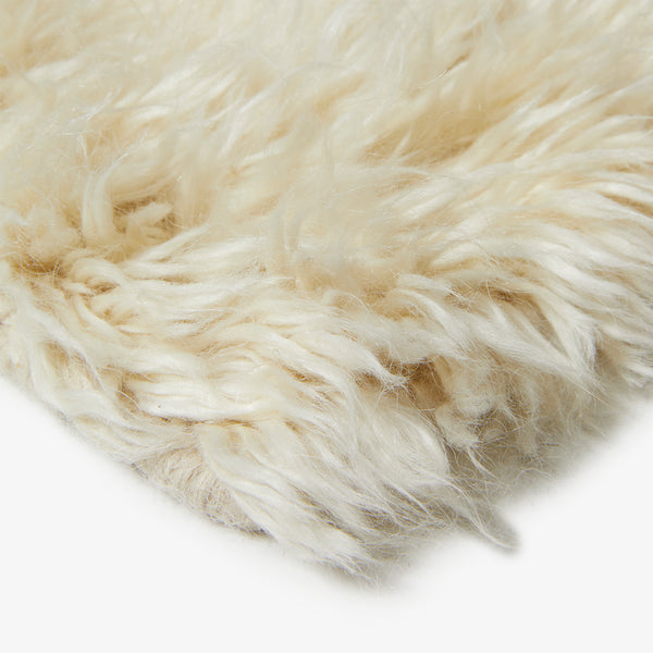 Close-up of cream-colored fur with a soft, wavy texture.