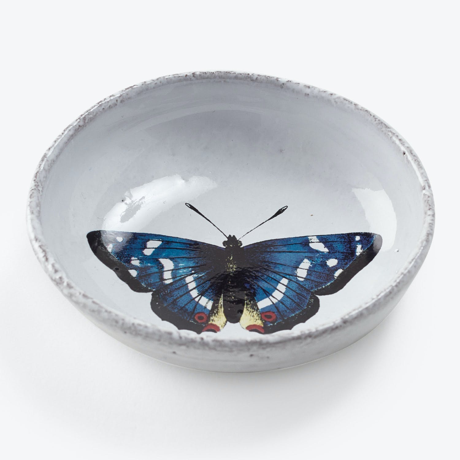 Ceramic bowl with distressed edge showcases vibrant butterfly illustration inside.