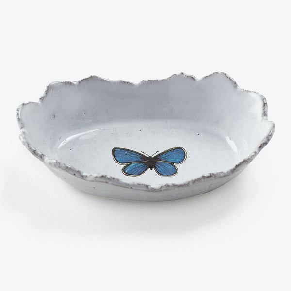 Handcrafted ceramic dish with scalloped edge and blue butterfly illustration.