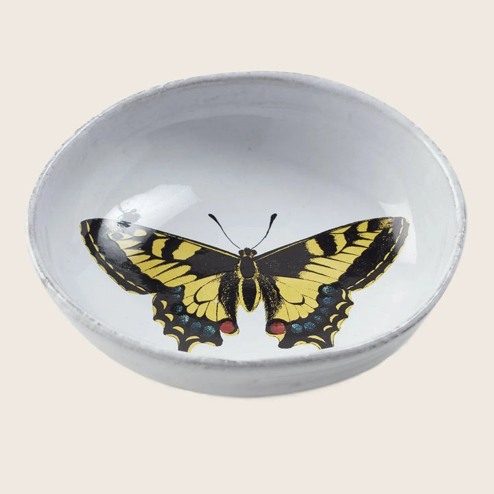 Decorative ceramic bowl featuring a butterfly design on reflective surface.