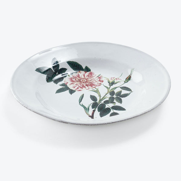 Handcrafted circular plate with a single floral centerpiece, pink hues.