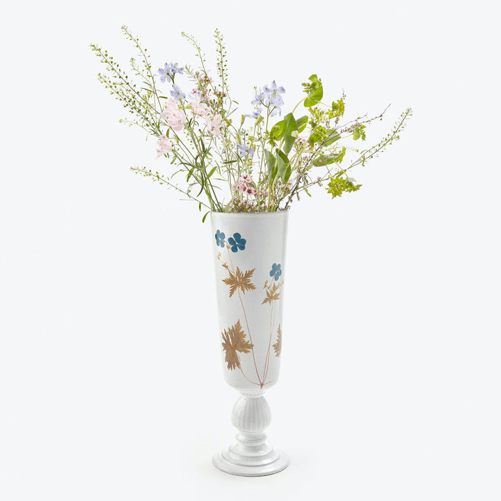 Decorative blue and gold vase with delicate floral arrangement.