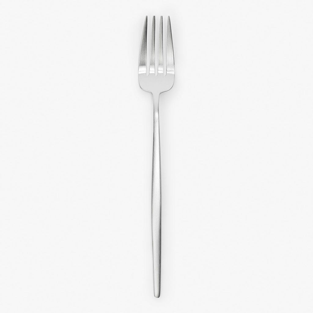 Minimalist silver fork with four tines against white backdrop.