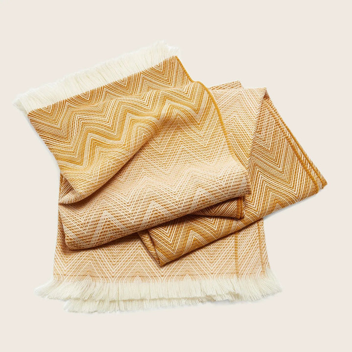 Folded textile with a gold and cream chevron pattern.