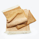 Folded textile with a gold and cream chevron pattern.