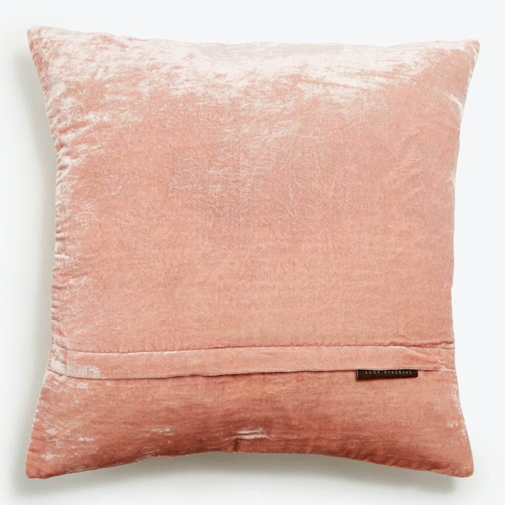 Plush pink throw pillow with velvety texture and neat stitching.