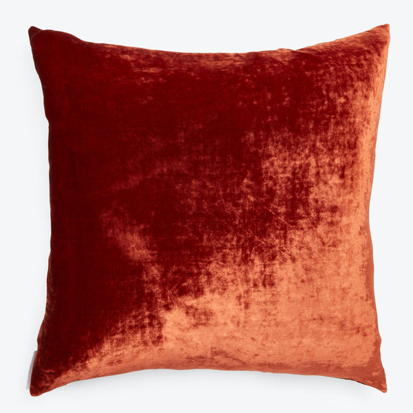 Plush burnt orange velvet pillow adds warmth to home decor.