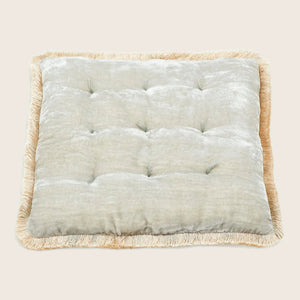 Square tufted pillow with quilted appearance and decorative fringe trim.