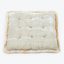 Square tufted pillow with quilted appearance and decorative fringe trim.