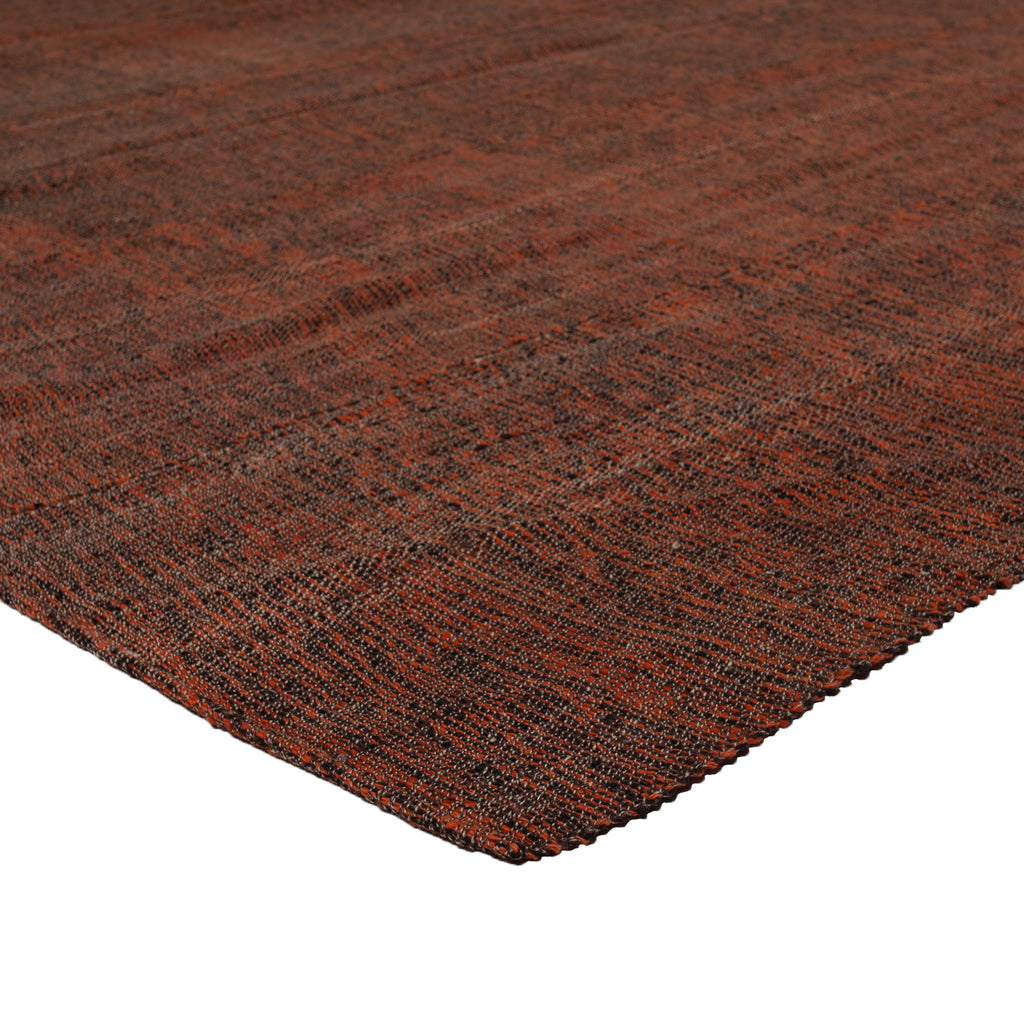 Close-up of durable, rusty orange carpet with dark speckles.