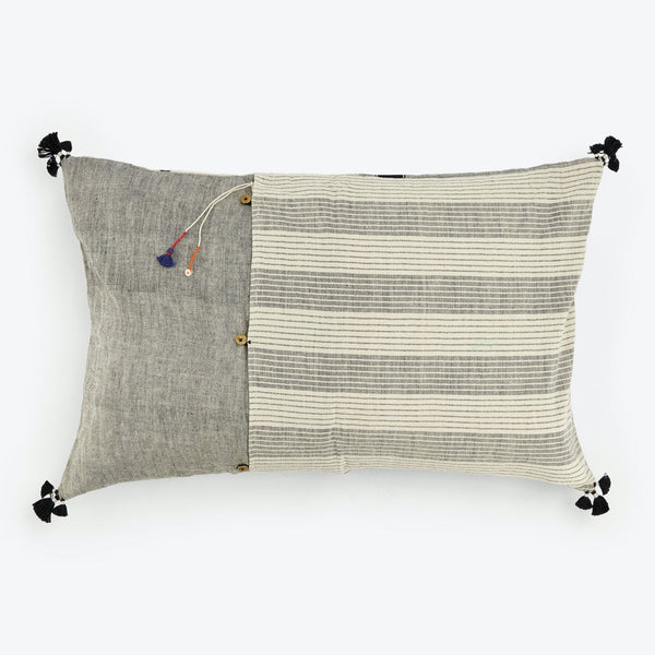 Rectangular decorative pillow with two-tone design, tassels, and buttons.