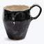Unique ceramic mug with unconventional design and handmade aesthetic.