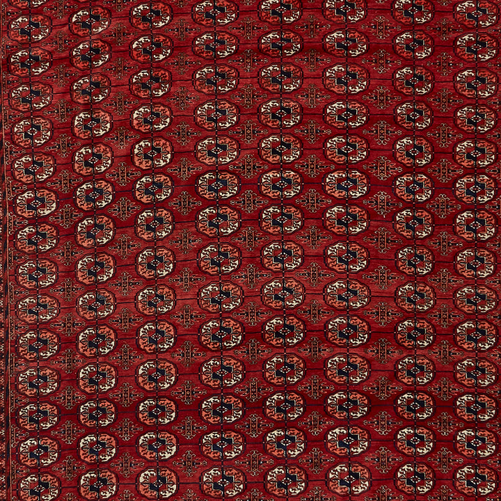Close-up of a traditional woven carpet with intricate red and black patterns
