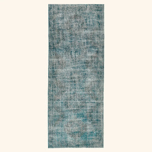 Vintage-style rectangular area rug in faded teal with abstract pattern