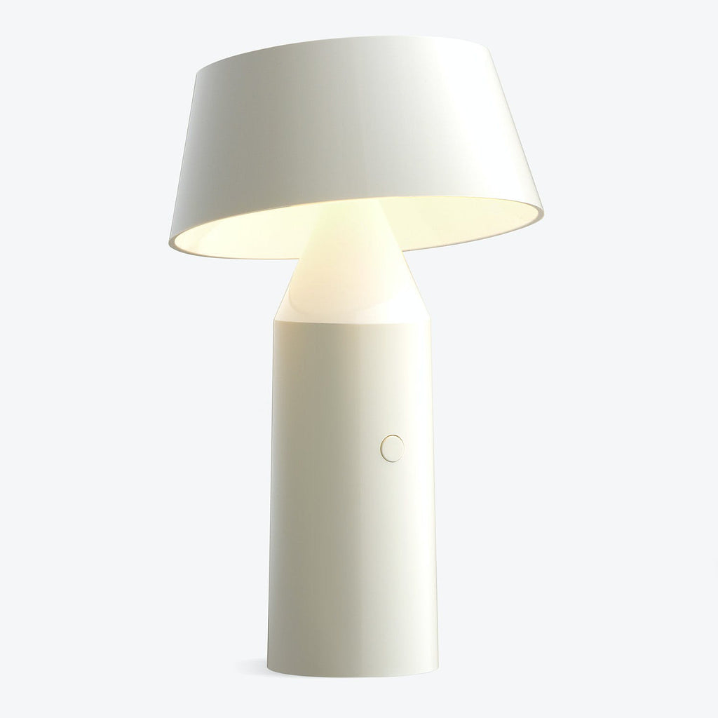 Modern table lamp with sleek design emitting warm glow.