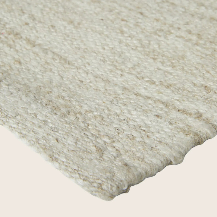 Close-up of textured fabric with natural color and mixed fibers.