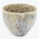 Artisanal ceramic bowl with speckled glaze in natural stone-like appearance.