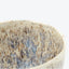 Close-up view of a rustic ceramic bowl with speckled texture.
