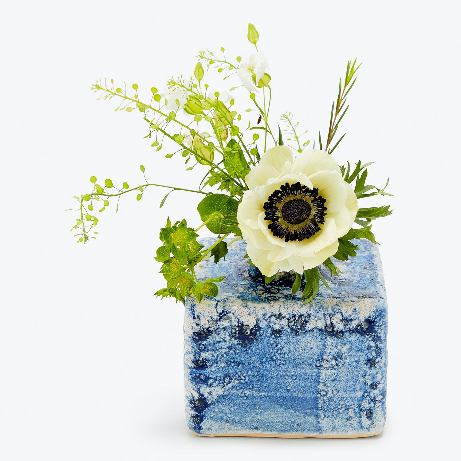 Vibrant floral arrangement in a rustic blue textured vase