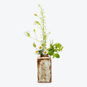 Rustic charm: repurposed metal can turned flower vase with wildflowers.