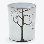 Cylindrical object with a stylized tree painting, possibly representing winter.