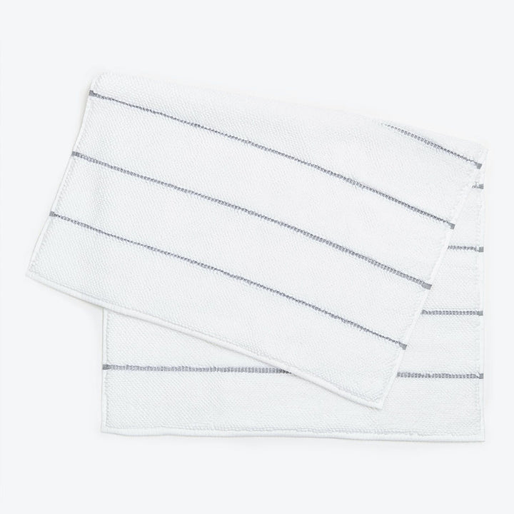 White terrycloth hand towels with textured stripes and metallic accents.