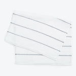 White terrycloth hand towels with textured stripes and metallic accents.