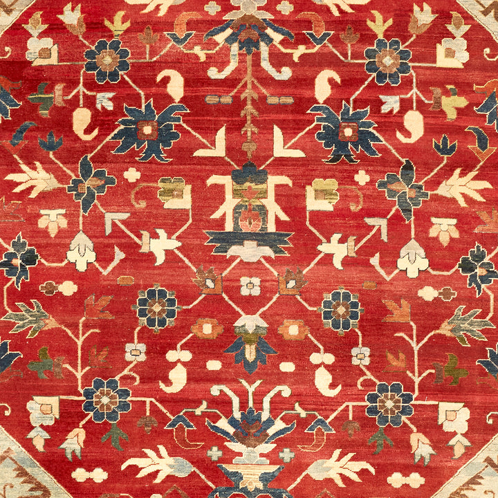 Ornate floral rug with rich red background and intricate motifs.