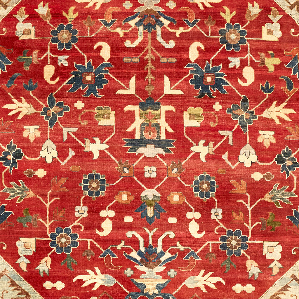 Ornate floral rug with rich red background and intricate motifs.