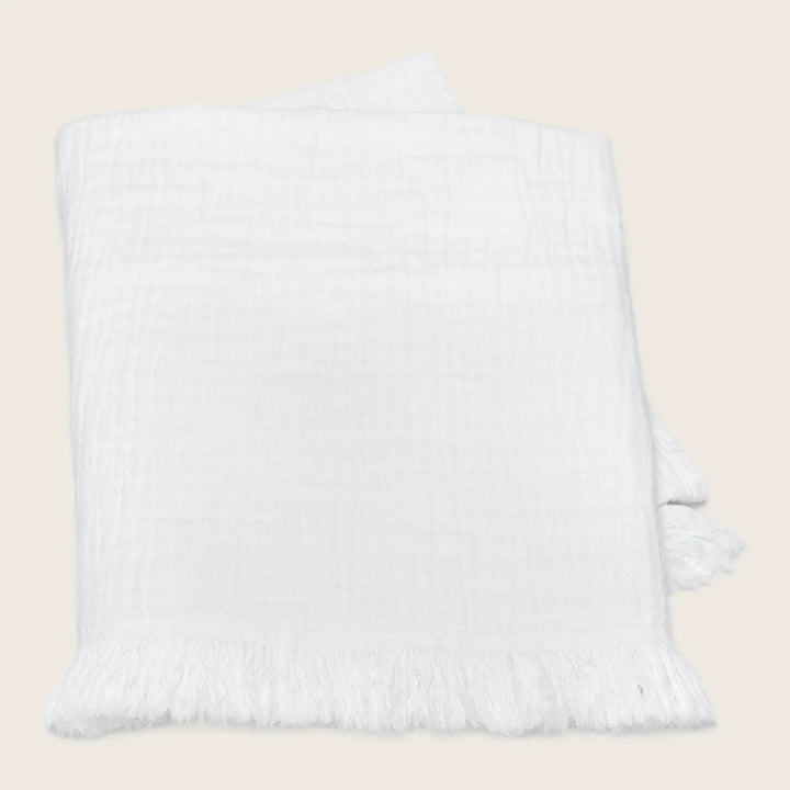 Minimalist white textile with delicate texture and fringe detail.
