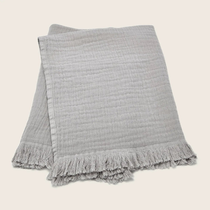 Soft and stylish, a versatile gray throw blanket with fringe.