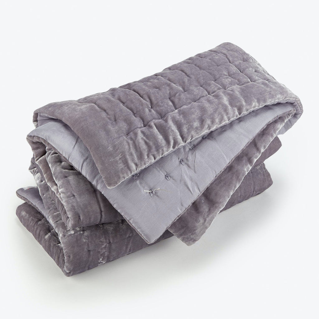 Folded grey weighted blanket with stitched squares for even distribution.