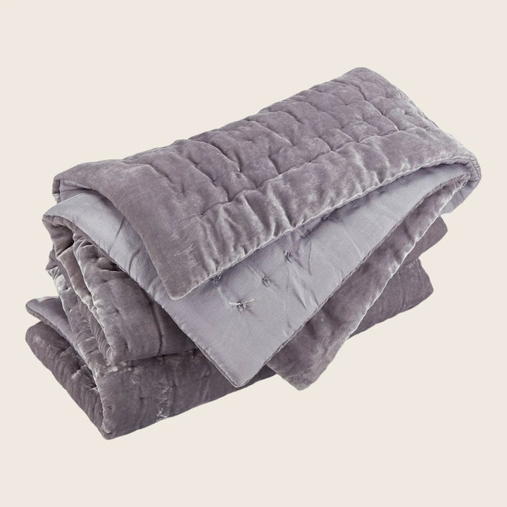 Folded weighted blanket with soft, velvety texture and decorative stitching patterns.