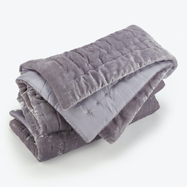 Folded grey weighted blanket with stitched squares for even distribution.