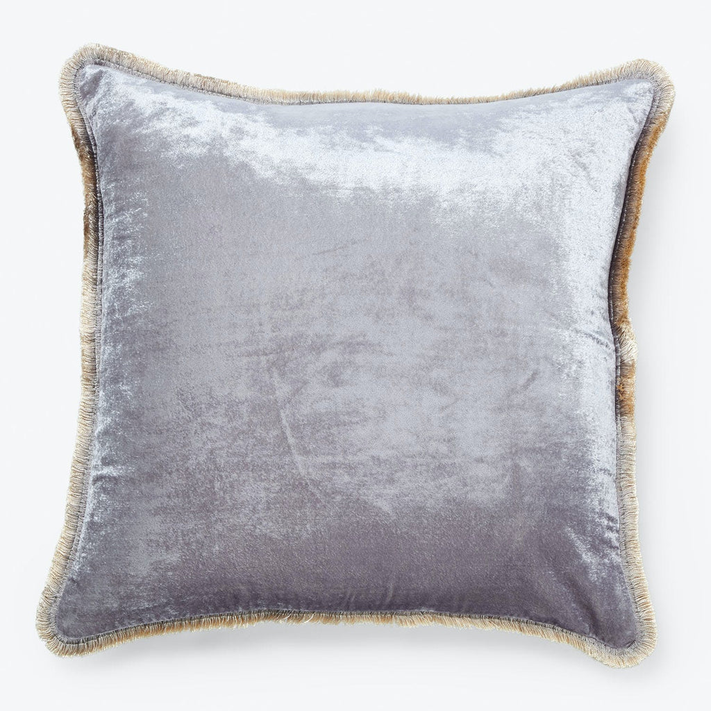 Velvet-like silver cushion with golden fringe exudes elegance and comfort.