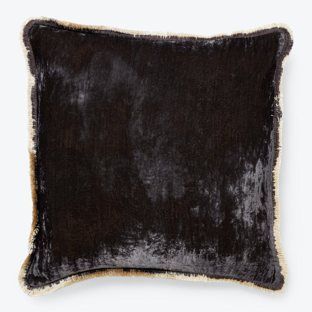 Black square pillow with plush velvet texture and gold fringe.