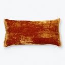 Rectangular burnt orange velvet pillow with fringe trim on white background