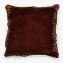 Square burgundy velvet pillow with cream trim against white backdrop.