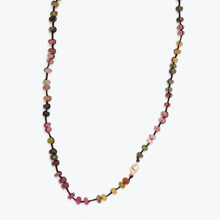 Colorful beaded necklace on white background showcases bohemian style.