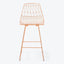Modern wireframe chair with copper finish exhibits sleek geometric design.