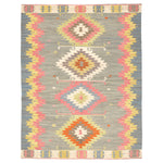 Vibrant tribal rug with symmetrical diamond patterns in muted background.