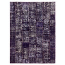 Rectangular area rug with distressed patchwork design in purple and grey.
