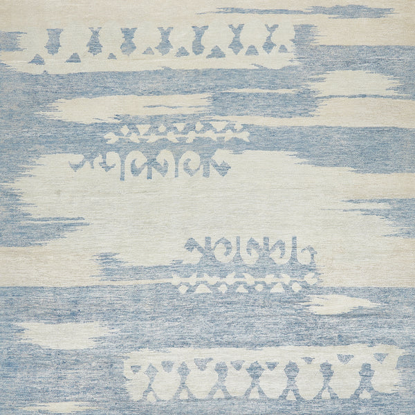 Abstract blue and off-white patterned fabric with tribal motifs.
