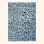 Abstract pattern featuring textured blue background with scattered darker splotches.