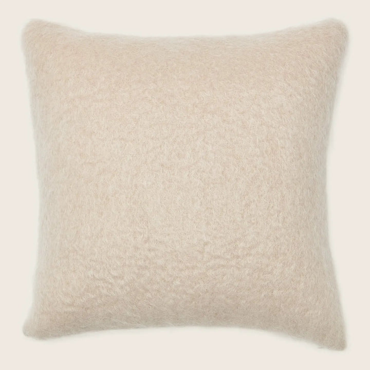 Soft, fluffy square pillow in light beige, perfect for comfort.